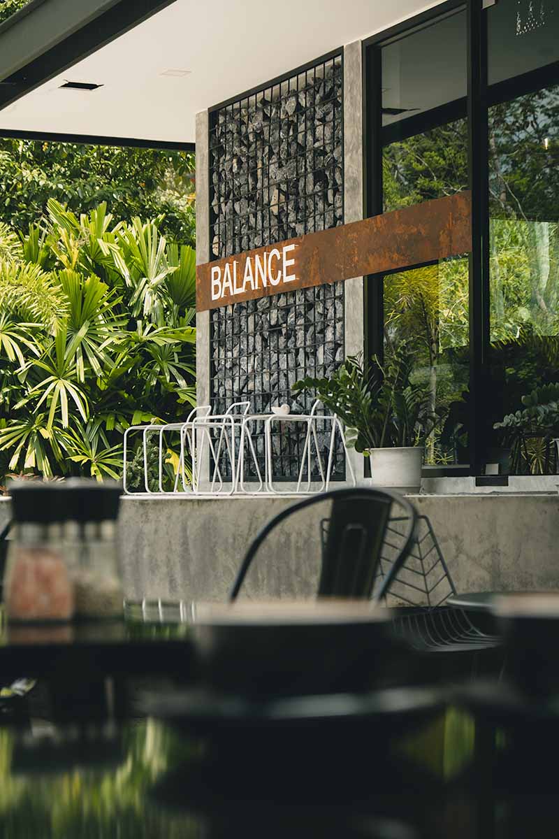 Balance Cafe's sign and front entrance with an out of focus table and coffee cup in the foreground.