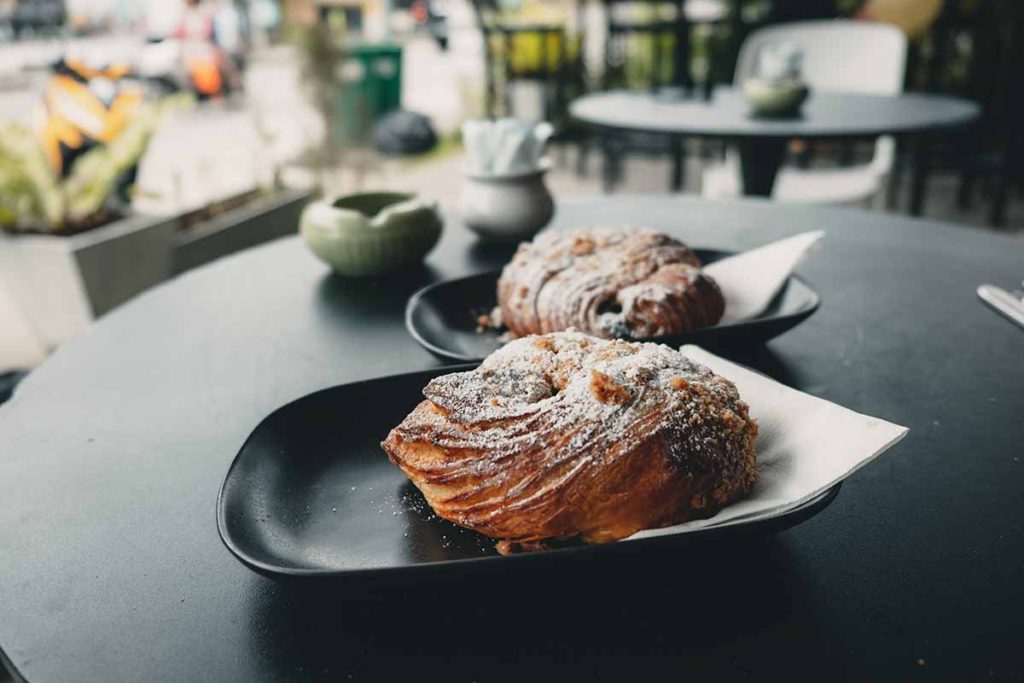 Two flour-topped pain au chocolate pastries served by the German Bakery.