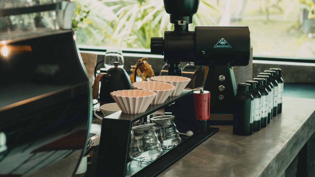A coffee bar with a grinder, drip coffee maker and espresso machine in Koh Phangan's Balance Cafe.