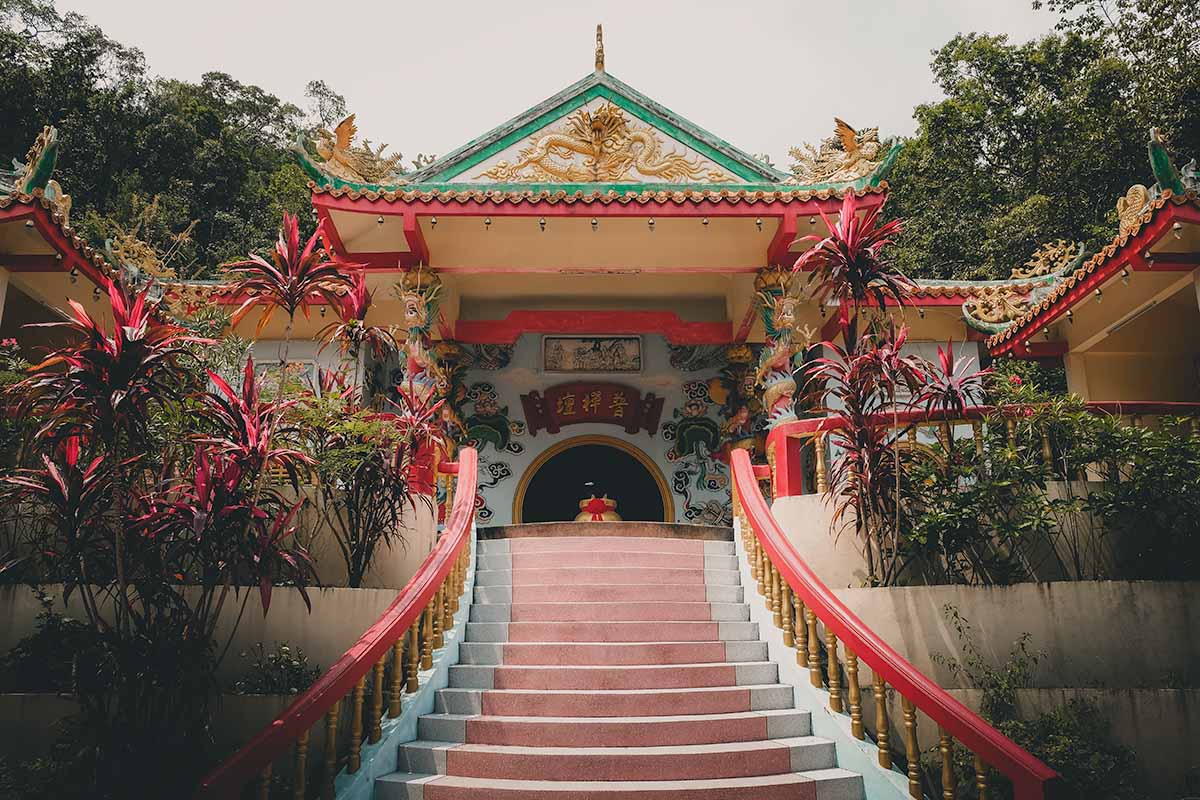 Red, white and gold stairs leading up to the colourful main prayer hall of the Chinese Temple.