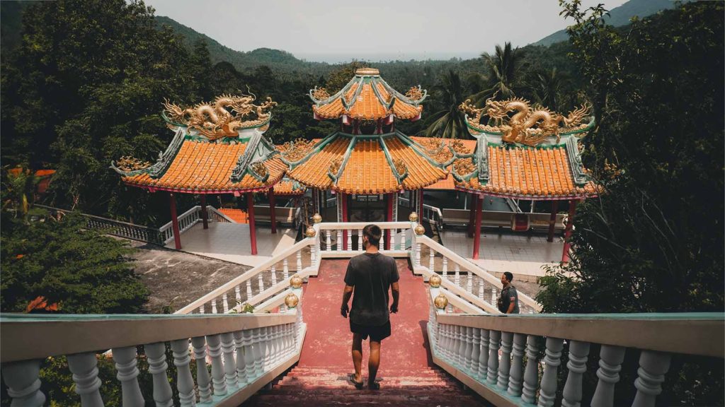A tourist walking down the stairs of the Chinese Temple.