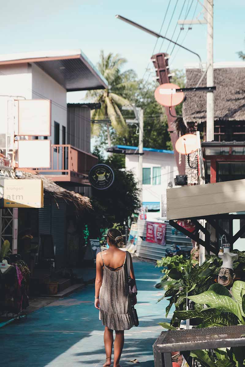 A female tourist wandering along the vibrant blue Walking Street.