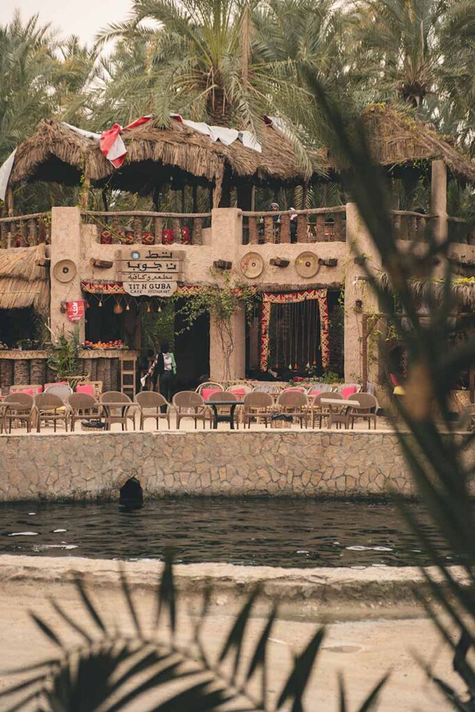 A cafe with outdoor and upstairs seating looking over Cleopatra's Pool.