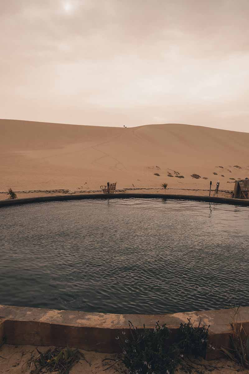 Haayat Hot Spring backed by a large sand dune.