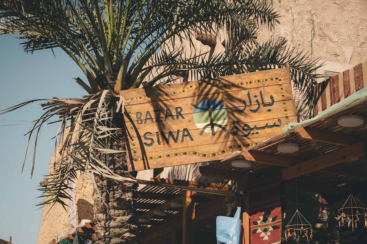 A wooden sign reading Bazar Siwa in English and Arabic.