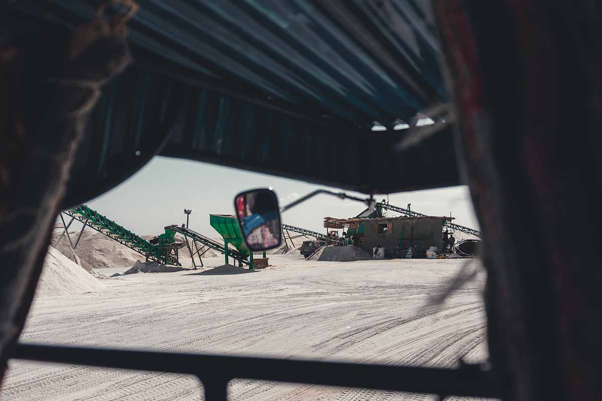 The machinery of Siwa Salt Mine and mounds of rock salt seen from the inside of a tuk tuk.