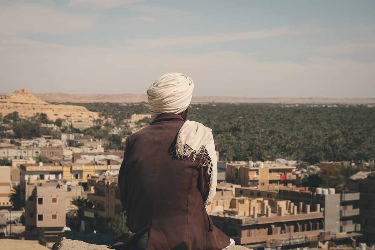 A local Siwi Berber sitting at the Shali Fortress Viewpoint looking out over Siwa Oasis.