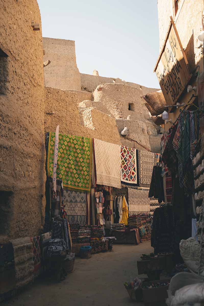 A narrow street local crafts on display on either side.