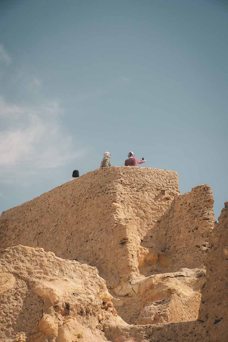 Three people standing at the Shali Fortress viewpoint, one of which is taking a selfie.