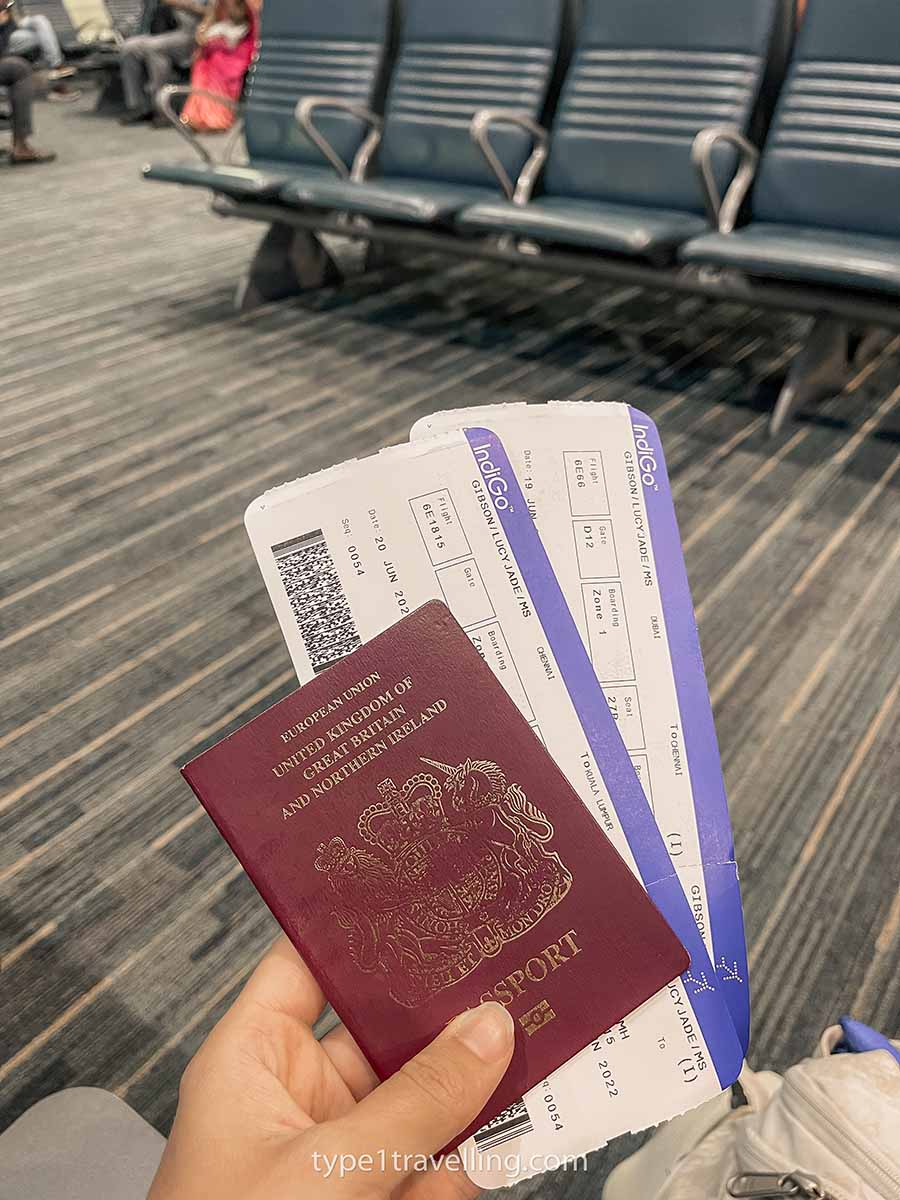 A hand holding a passport and two boarding passes.