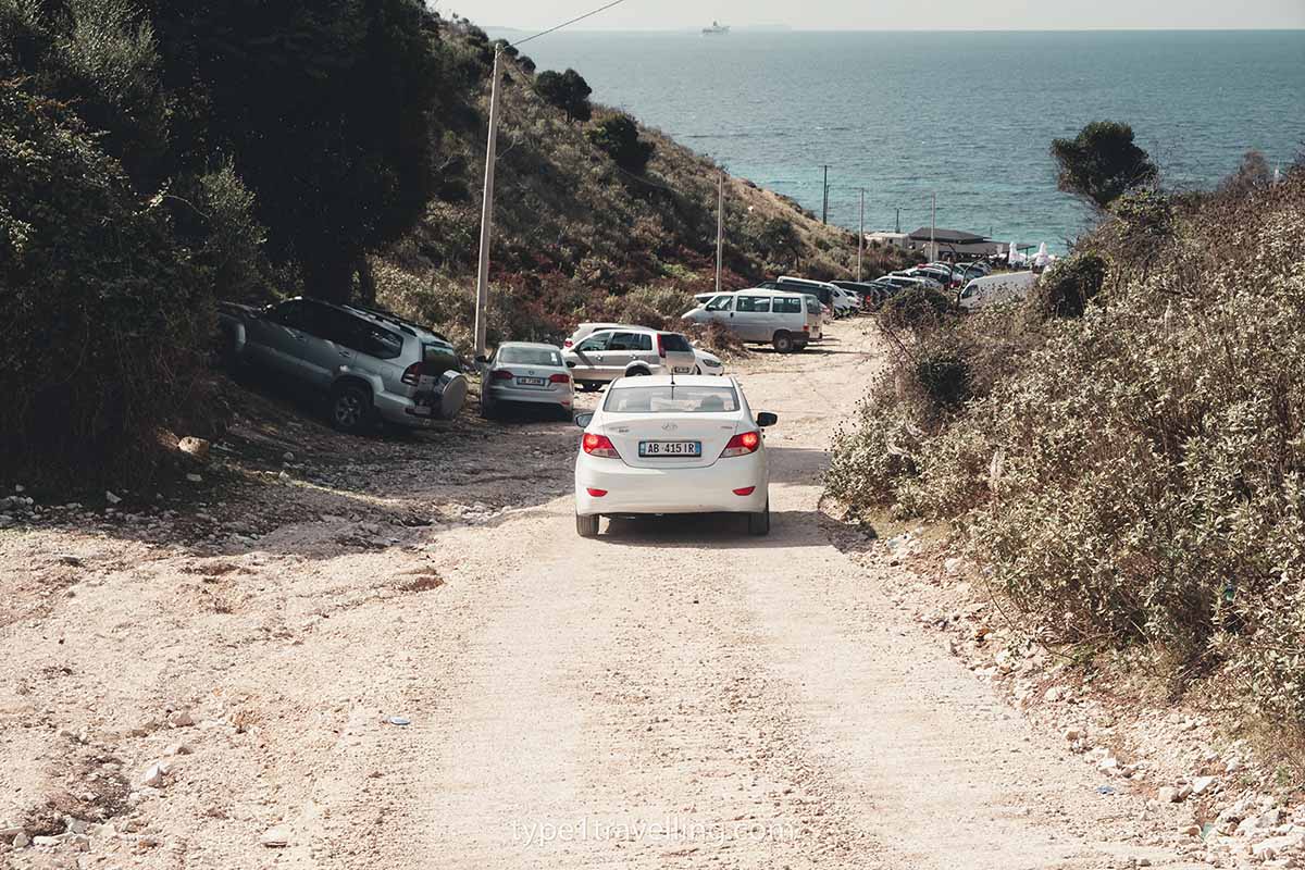 A white car breaking while approaching the gravel car park of Mirror Bech.