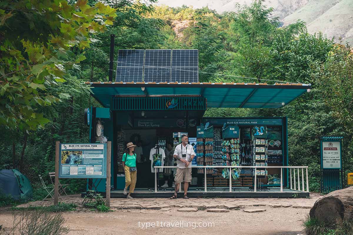 A man and woman standing outside the souvenir shop in the Blue Eye Nature Park.