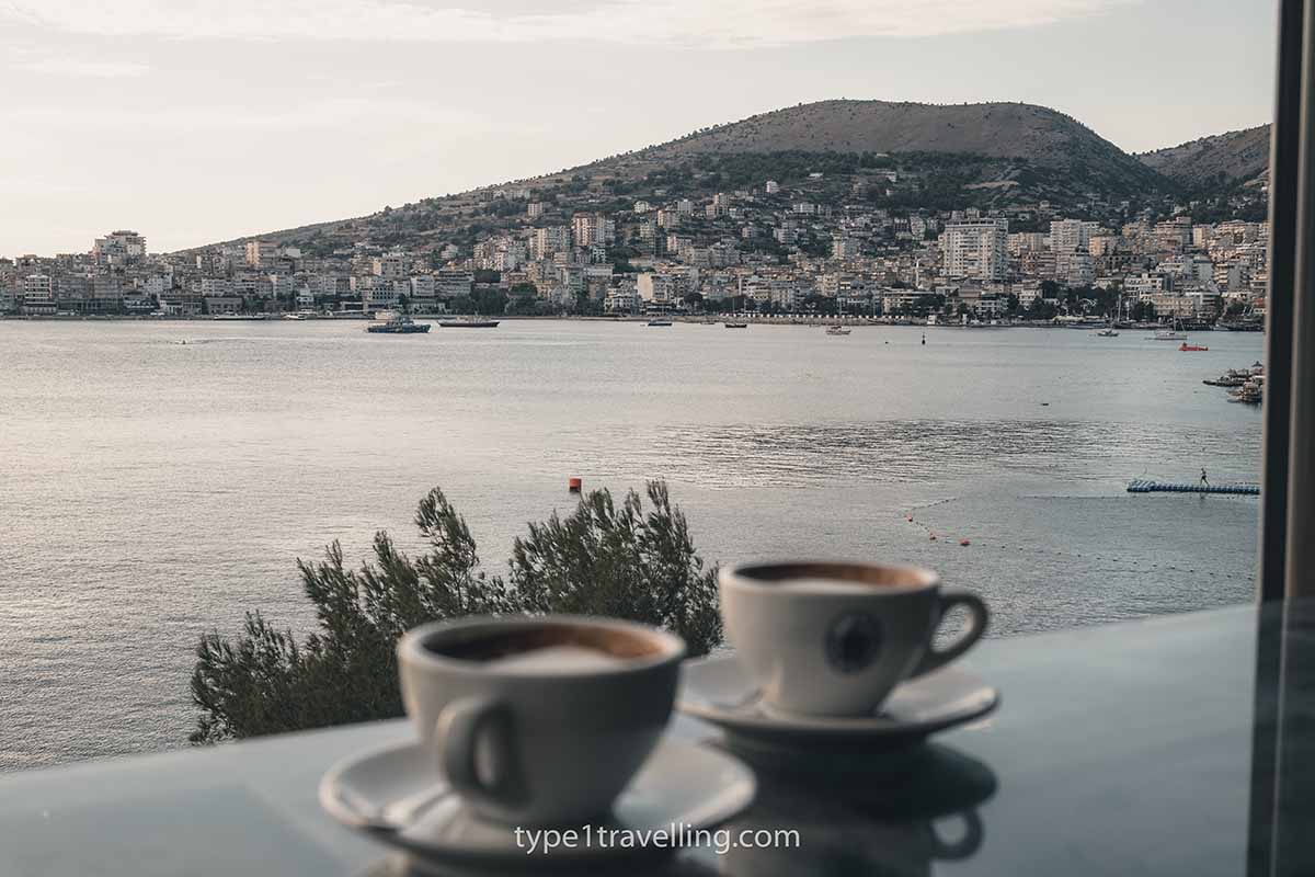 caffe-italia-view Two cups of coffee on a window table with the bay of Saranda in the background.