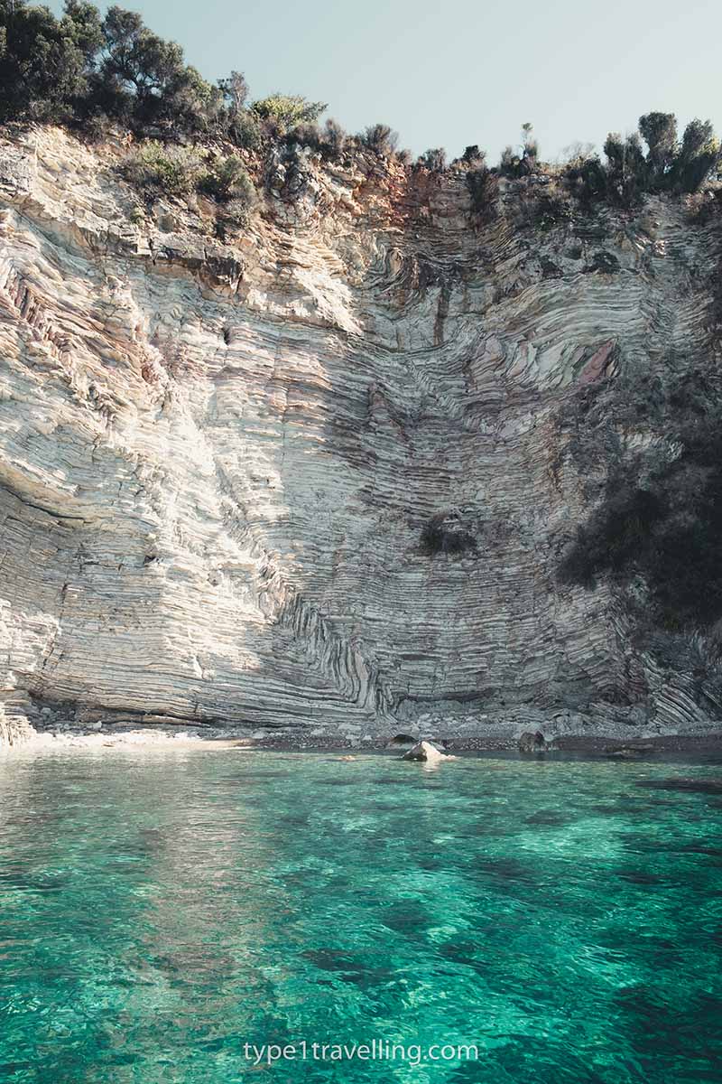 The eroded white cliff-face and turquoise water of Gremina Cove.