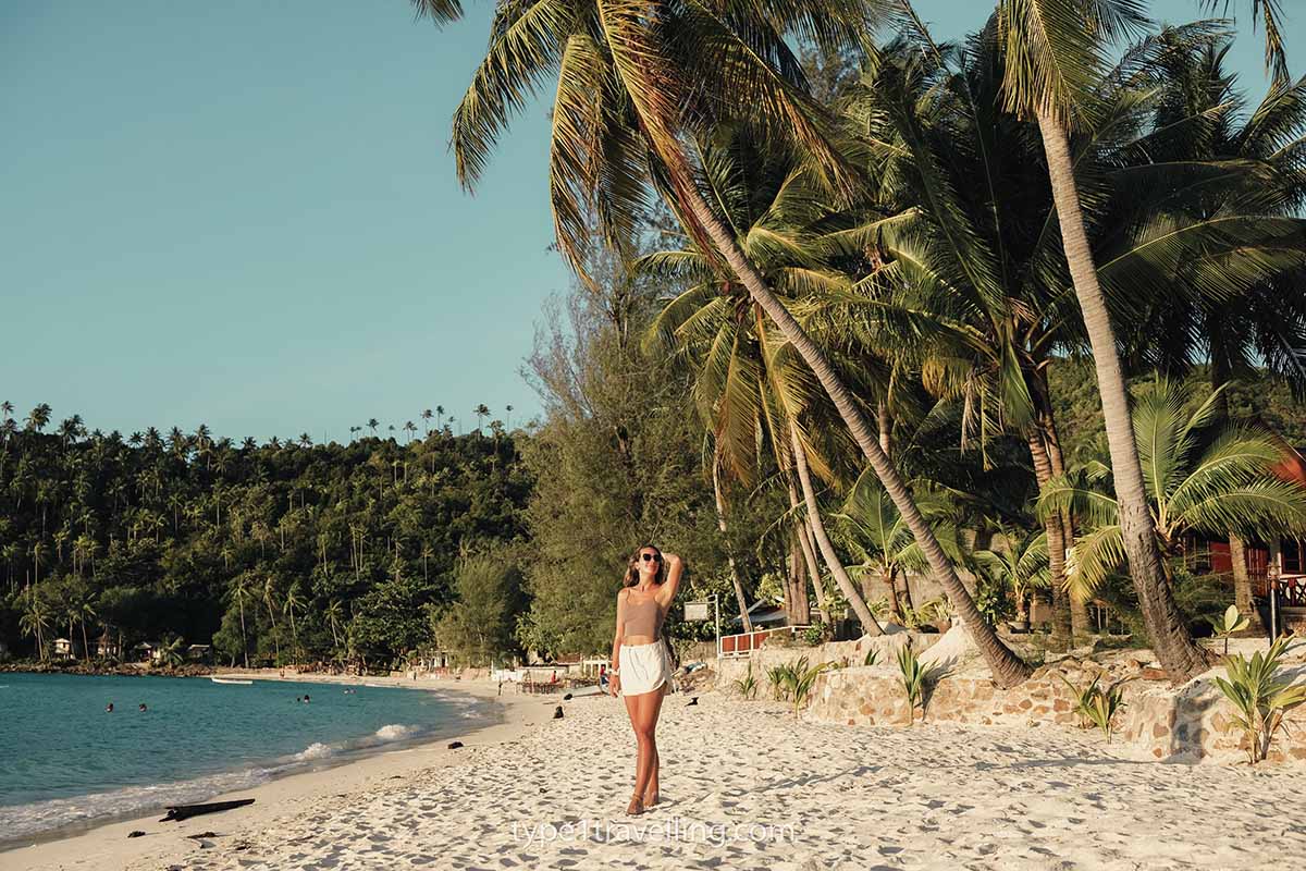 A woman looking up at the overhanging palm trees on Haad Salad.