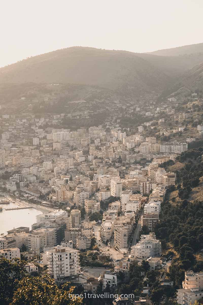 The high-rise apartment buildings of Saranda built into the hill as seen from above during golden hour.