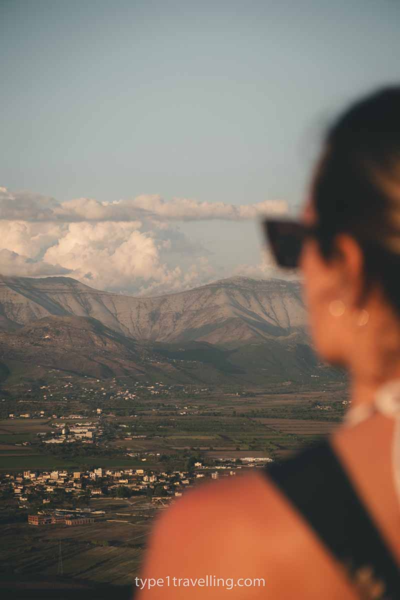 A woman looking out over the valley below and distant mountains.
