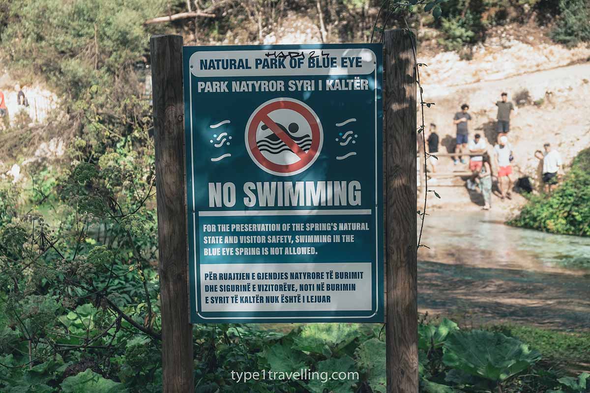 no-swimming-sign A sign stating that no swimming is allowed in the Blue Eye Spring in English and Albanian.