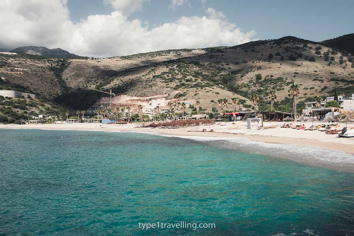 jale-beach-himare The full stretch of Jale Beach with large green hills in the background.