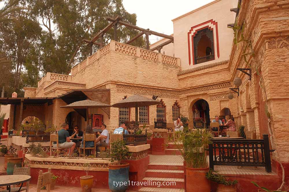 Several people sitting at tables in the outdoor seating area of Cafe Maure in Agadir Medina.