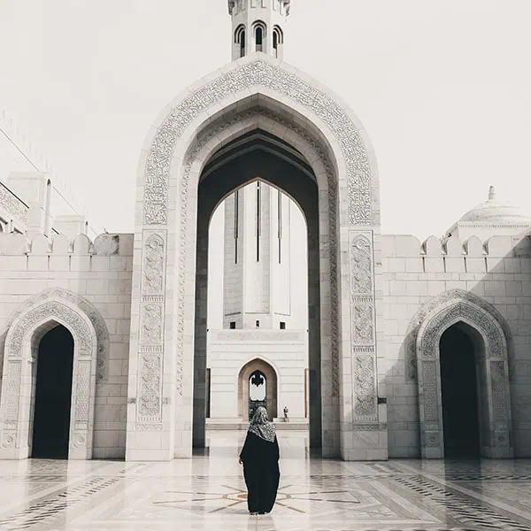 muscat-oman-travel A woman walking along a marble floor in Sultan Qaboos Grand Mosque in Muscat.