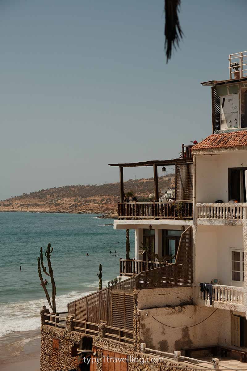 A multi-floor hostel with raised terrace overlooking Taghazout Beach.