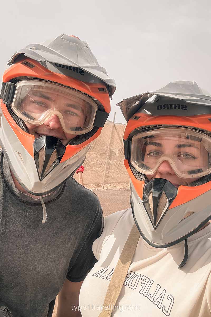 A selfie of a couple wearing full face helmets and goggles.