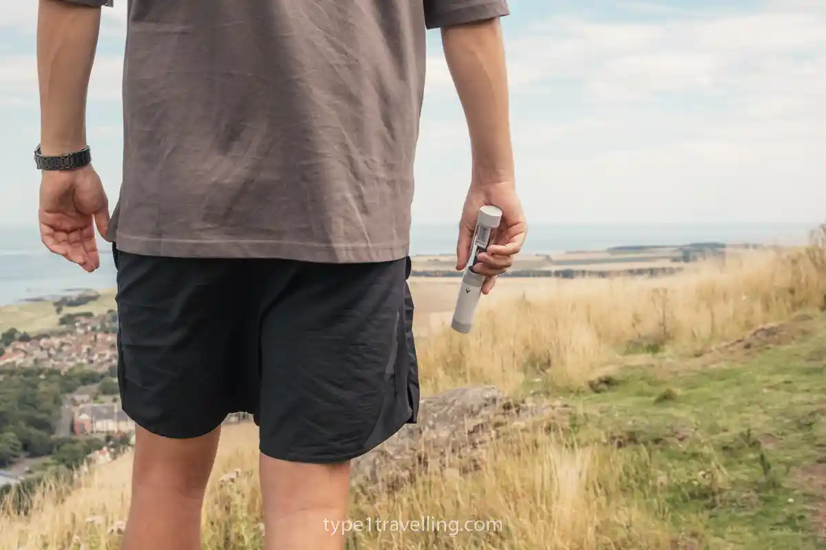 Sam holding a TempraMed VIVI Cap case at his side while walking on a hill.